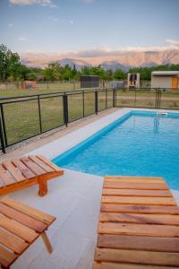 une piscine avec un banc et une clôture dans l'établissement Aires de Paz, à Las Calles