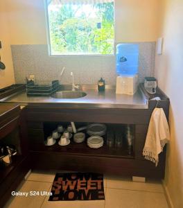 a kitchen counter with a sink and a window at Lá vie taipu in Marau +7 photos