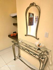 une table en verre avec un miroir sur un mur dans l'établissement Lá vie taipu, à Marau 7 autres photos