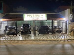 a gate with cars parked in a parking lot at Pousada Sagrada Devoção in Aparecida