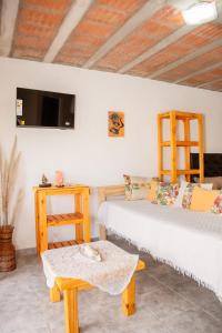 Cette chambre comprend 2 lits, une table et une télévision. dans l'établissement Aires de Paz, à Las Calles