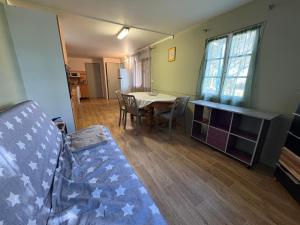 a living room with a table and a dining room at Chalet Proche mer in Latour-Bas-Elne