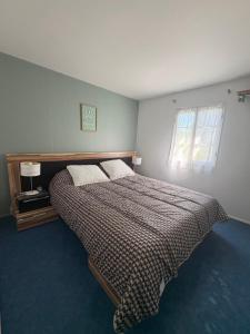 a bedroom with a bed and a window at Chalet Proche mer in Latour-Bas-Elne