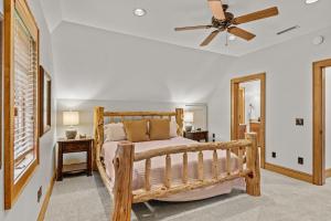 - une chambre avec un lit en bois et un ventilateur de plafond dans l'établissement Creekside Hideaway at The Farm, à Banner Elk