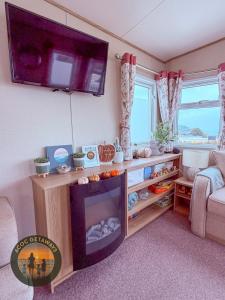 a living room with a fireplace and a flat screen tv at 3 Bedroom Caravan with stunning panoramic sea view in New Quay +29 photos