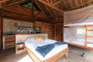 a bedroom with a bed in a wooden cabin at Paraiso Ahimsa in Buritaca