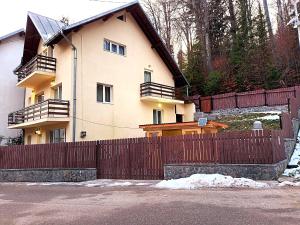 una casa con una valla de madera delante de ella en Casa Sonne, en Buşteni