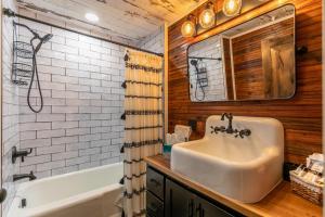 a bathroom with a sink and a tub and a mirror at Up the Creek in Linville +23 photos