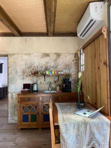 a kitchen with a table and a sink in a room at צימר השקדיה in ‘En Hod