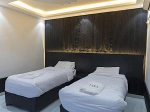 two beds sitting next to each other in a room at Lyva chalet in Al Rama