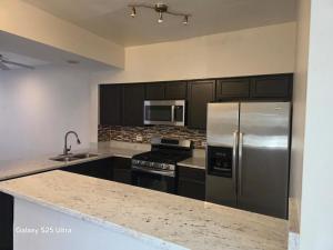 a kitchen with a stainless steel refrigerator and a stove at 2 bedroom house available in Waukegan