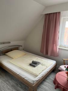 Un dormitorio con una cama con un libro encima. en Hotel Lindenhof, 