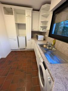 a kitchen with a sink and a washing machine at Villa Heusenstamm in Heusenstamm
