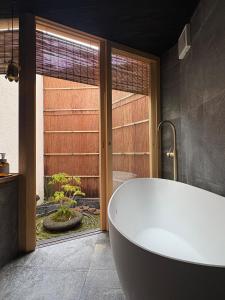 eine Badewanne im Bad mit Fenster in der Unterkunft 逢譚-atan- in Kyoto