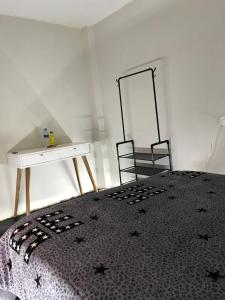 Schlafzimmer mit einem Bett mit einem Tisch und einem Spiegel in der Unterkunft Habitación en el corazón de Chiclayo in Chiclayo