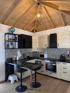 a kitchen with a black counter top and wooden ceilings at Villa Barbosa in Quintiães