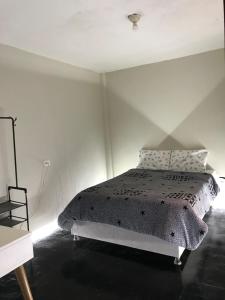 ein weißes Schlafzimmer mit einem Bett und einem Stuhl in der Unterkunft Habitación en el corazón de Chiclayo in Chiclayo