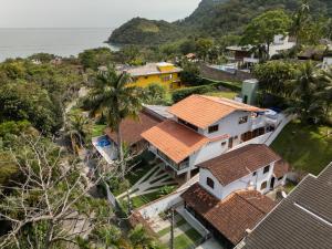 an aerial view of a house with trees and the ocean at Casa Varanda Guaecá Pet Friendly, Heated Pool in São Sebastião