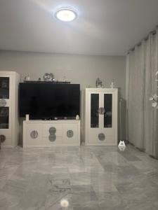 a living room with a flat screen tv and white cabinets at Habitaciones acogedoras buen trato in Mairena del Aljarafe