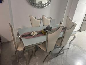 a dining room table with chairs and a mirror at Habitaciones acogedoras buen trato in Mairena del Aljarafe