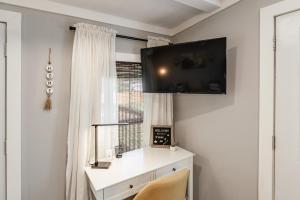 Habitación con escritorio y TV en la pared. en Cozy Villa Stay Gorgeous Views Unit C, en Madison