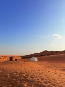 une tente au milieu d'un désert dans l'établissement Bedouin Stars, à Ḩawīyah