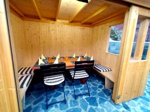 Una habitación de madera con una mesa larga y sillas. en Casa Sonne, en Buşteni