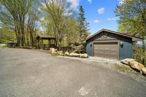 a house with a garage next to a road at Sit Stay Play in Beech Mountain