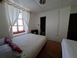 a bedroom with two beds and a window at Nativo Atacama in El Cerrillo
