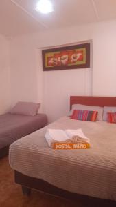a bedroom with two beds and a picture on the wall at Nativo Atacama in El Cerrillo