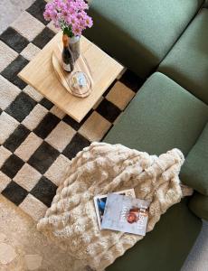 Eine Decke auf einem Sofa mit einem Tisch und Blumen in der Unterkunft Bergherz Berchtesgaden in Berchtesgaden + 22 Fotos