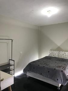 ein weißes Schlafzimmer mit einem Bett und einem Tisch in der Unterkunft Habitación en el corazón de Chiclayo in Chiclayo