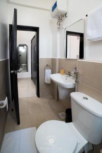 a bathroom with a toilet and a sink at Lakeside Serenity Stylish 2BR Getaway - Entebbe in Entebbe +51 photos