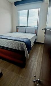 a bedroom with a bed and a large window at Beautiful cozy very central apartment in San José  +54 photos