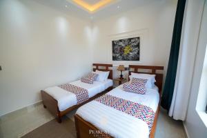 a room with two beds and a window at Lakeside Serenity Stylish 2BR Getaway - Entebbe in Entebbe