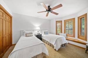 two beds in a bedroom with a ceiling fan at Chetola: Sierra 1 in Blowing Rock