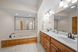 a bathroom with two sinks and a tub and a mirror at Chetola: Sierra 1 in Blowing Rock +17 photos
