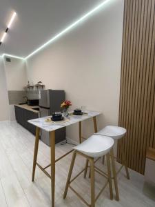 eine Küche mit einem Tisch und zwei weißen Stühlen in der Unterkunft Comfort Studio Apartment in Almaty + 27 Fotos