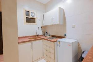 a small kitchen with white cabinets and a refrigerator at فندق اكارم جازان Akarem Jazan in Jazan