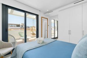 a bedroom with a blue bed and a balcony at Casa Vega, a un minuto de la playa, PARKING included in Estepona