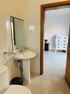 a bathroom with a sink and a toilet and a mirror at Apartamentos Ramos 3 in Santa Maria +32 photos