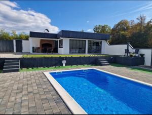 a house with a swimming pool in front of a house at Villa Dunja Prijedor in Prijedor