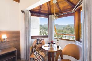 a room with a table and chairs and a window at Pousada Valle das Flores Monte Verde in Monte Verde