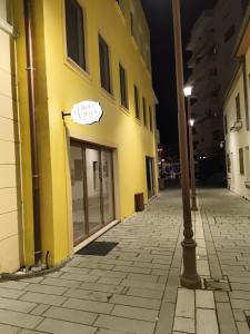 a yellow building with a sign on the door at Ora E Vjeter in Vlorë