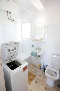 ein weißes Badezimmer mit Waschbecken und Toilette in der Unterkunft Beachfront Lagonisi Apt 1 Minute From Grand Resort in Kalívia Thorikoú
