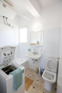 ein weißes Badezimmer mit Waschbecken und Toilette in der Unterkunft Beachfront Lagonisi Apt 1 Minute From Grand Resort in Kalívia Thorikoú + 36 Fotos