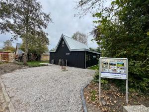 a black building with a sign in front of it at Vakantiehuis Lucky in Ons Belang