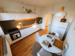 ピエシュチャニにあるComfort Homeの小さなキッチン(白いテーブル、椅子付)