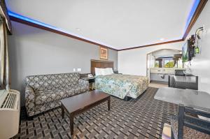 a hotel room with a couch and a bed at Starlight Inn South El Monte in South El Monte