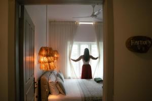 a woman in a red dress looking out of a window at Utopia Varkala - Boutique stay in Odayam rice fields in Varkala